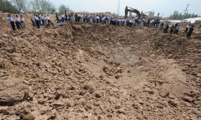 In this file photo, Chinese gather around a crater of what used to be the Jingxin Mining company which produced and processed quartz sand in Fengyang, in China's Anhui province. China is the world's largest producer of rare earth minerals. (AFP/AFP/Getty Images)