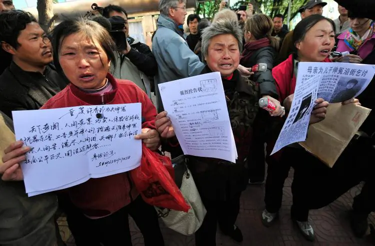 Agitated Chinese petitioners show documents during a gathering outside a courthouse in Beijing, China on April 3, 2008. (Teh Eng Koon/AFP/Getty Images)