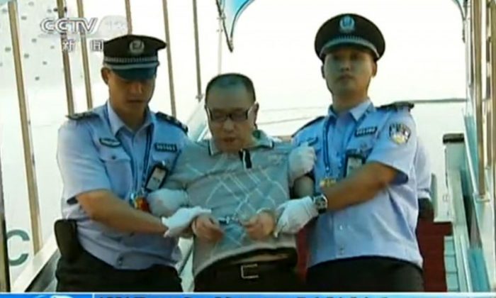 A screenshot taken on July 23, 2011 from China's Central Television shows fugitive Chinese businessman Lai Changxing escorted by police after he landed in Beijing aboard a civilian flight in the custody of Canadian police. (China’s Central Television/STR/AFP/Getty Images)