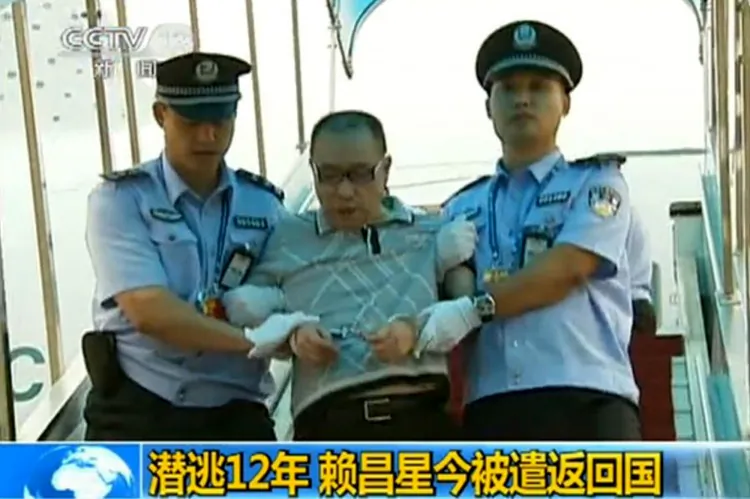 A screenshot taken on July 23, 2011 from China's Central Television shows fugitive Chinese businessman Lai Changxing escorted by police after he landed in Beijing aboard a civilian flight in the custody of Canadian police. (China’s Central Television/STR/AFP/Getty Images)