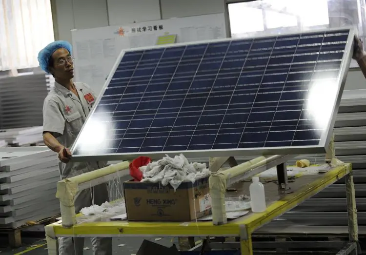 A worker lifts a solar panel in the Yingli Solar factory in Baoding, Hebei province, on September 30, 2010. (Peter Parks/AFP via Getty Images)