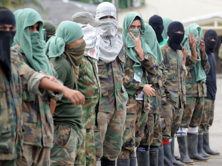 Members of 'Los Rastrojos' bandit group cover their faces with towels and balaclavas as they surrender at the Voltigeros Battalion on May 21, 2009, in Uraba, Antioquia department, Colombia. (Raul Arboleda/AFP/Getty Images )
