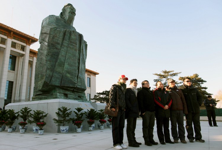 NOW YOU SEE HIM: Chinese tourists pose in front of Confucius outside the National Museum at Tiananmen Square in January. The statue was removed without explanation four months later, highlighting the Communist Party's ambiguity in executing its new brand of Confucius propaganda. (STR/AFP/Getty Images) NOW YOU SEE HIM: Chinese tourists pose in front of Confucius outside the National Museum at Tiananmen Square in January. The statue was removed without explanation four months later, highlighting the Communist Party's ambiguity in executing its new brand of Confucius propaganda. (STR/AFP/Getty Images)