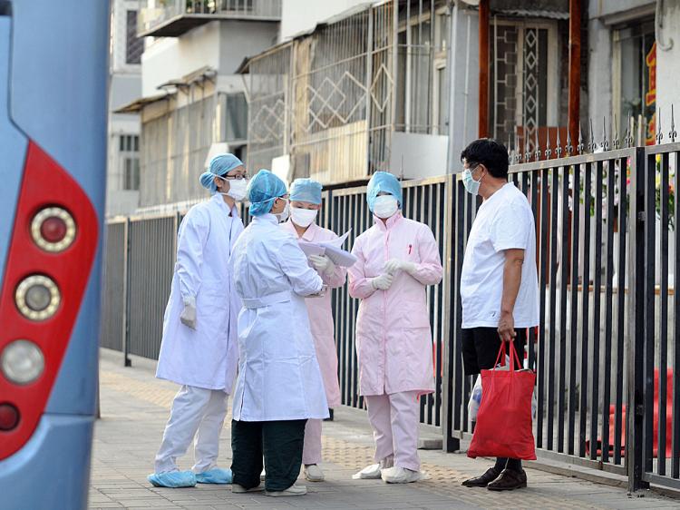 Chinese medical personnel check the Beijing neighborhood near a hostel where a group of school children are quarantined after seven people in their school were diagnosed with the swine flu, July 2, 2009. (AFP/Getty Images) Chinese medical personnel check the Beijing neighborhood near a hostel where a group of school children are quarantined after seven people in their school were diagnosed with the swine flu, July 2, 2009. (AFP/Getty Images)