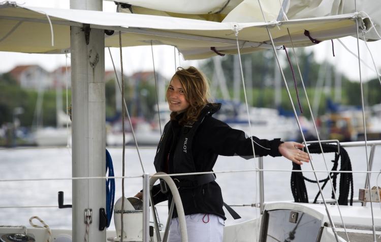 Dutch Laura Dekker, 14, waves goodbye as she leaves the port in Den Osse on August 4. Laura Dekker set sail on her yacht, Guppy, for Portugal, from where she will begin her bid to become the youngest person to sail solo around the world.  (Marcel Antonisse/Getty Images)