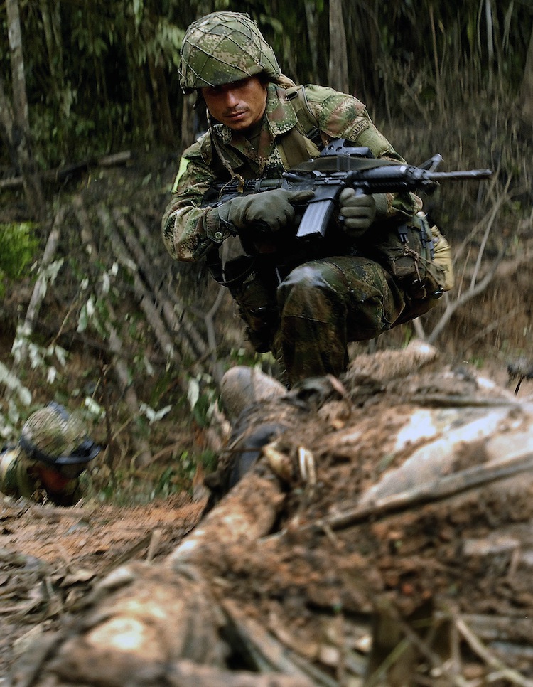 A Colombian soldier stares at the body of a member of the Revolutionary Armed Forces of Colombia (FARC), in a rural zone in Puerto Rico, Meta department, in Colombia, on July 25, 2009. (Luis Ramirez/AFP/GettyImages) Epoch Times Photo