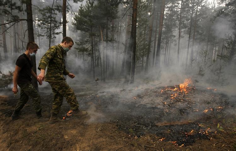 Russian soldiers kick dirt on a forest fire some 130 kilometers from Moscow in Beloomut on August 1. Firefighters fought an uphill battle the fires that have already killed 30 people, destroyed thousands of homes and mobilized hundreds of thousands of emergency workers. (Artyom Korotayev/Getty Images )