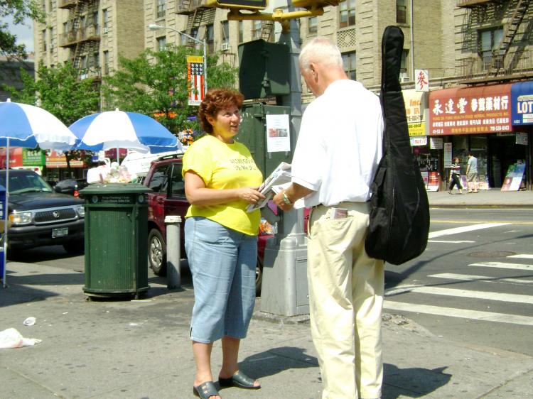 SPEAKING OUT: Maria Vassong speaks to passersby about false claims being made in propaganda being distributed in Flushing, Queens by pro Chinese Communist groups. (The Epoch Times)