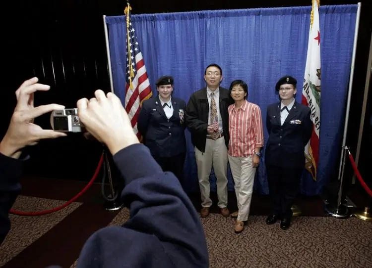 Newly naturalized U.S. citizens have their photo taken with members of the U.S. Air Force Junior ROTC color guard after being sworn in as U.S. citizens during a naturalization ceremony in San Francisco, on May 23, 2006. (Justin Sullivan/Getty Images)
