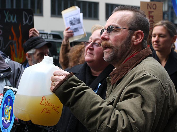 TOXIC: Craig Saunter holds up a jug of contaminated water from his well in Dimick, Penn. His once pristine well water was poisoned by a natural gas plant that opened near his home. (Tara Macisaac/The Epoch Times)