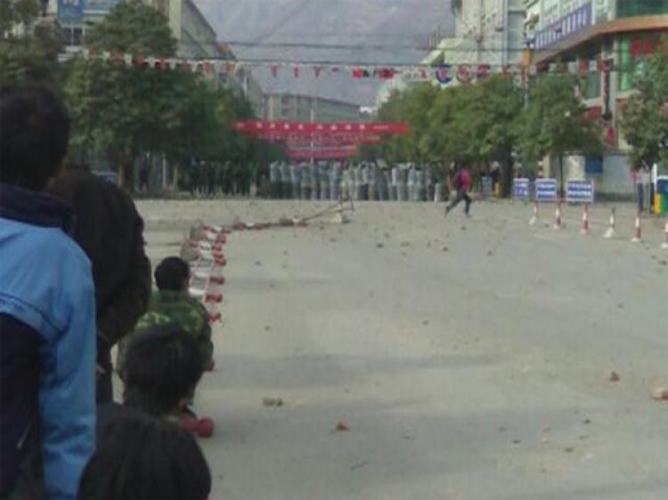 People watch armed police from the side of the street. Thousands of people rioted in Gansu province protesting the regime's move of an office, resulting in a termination of reconstruction of houses affected by the Sichuan earthquake. (The Epoch Times) People watch armed police from the side of the street. Thousands of people rioted in Gansu province protesting the regime's move of an office, resulting in a termination of reconstruction of houses affected by the Sichuan earthquake. (The Epoch Times)