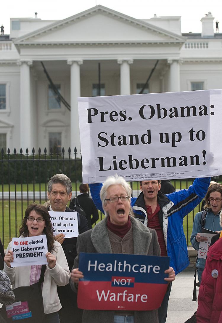 Protesters chant slogans urging Obama to enable passage of the Senate health care plan despite independent Senator from Connecticut Joe Lieberman's call for the axing of Medicare expansion, in front of the White House in Washington, D.C. on Dec. 15. (Nicholas Kamm/AFP/Getty Images)