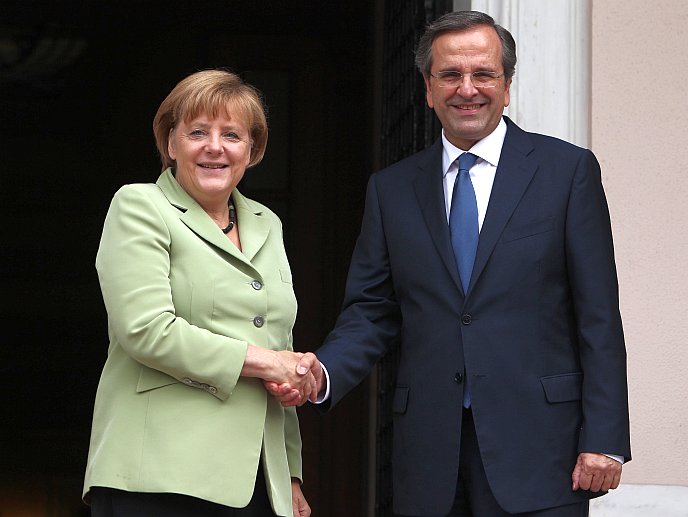 Greek Prime Minister Antonis Samaras (R) and German Chancellor Angela Merkel shake hands at the Maximos Mansion in Athens on Oct. 9. Merkel told Greece that the "tough path" of painful spending cuts will pay off, as tens of thousands of protesters gathered throughout the capital in a show of anger against her visit to the eurozone's most indebted nation. (Thanassis Stavrakis/AFP/Getty Images)