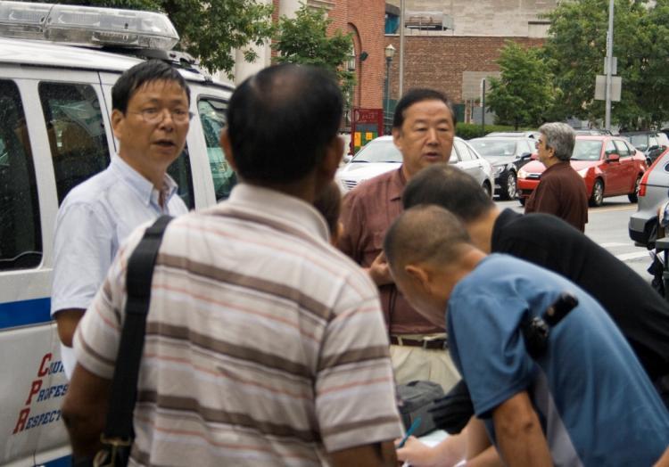HATE TABLE: A table to distribute hate materials and gather signatures against Falun Gong was set up on the corner of Main Street and Sanford Avenue on Aug. 2. (Genevieve Long/The Epoch Times)