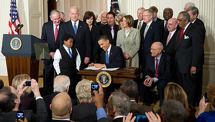 President Barack Obama, surrounded by Democratic lawmakers, signs the health care insurance reform legislation during a ceremony in the East Room of the White House, March 23, 2010. The Department of Justice will not appeal a ruling by Atlanta's 11th Circuit Court that the mandatory insurance requirement is unconstitutional. (SAUL LOEB/AFP/Getty Images) President Barack Obama, surrounded by Democratic lawmakers, signs the health care insurance reform legislation during a ceremony in the East Room of the White House, March 23, 2010. The Department of Justice will not appeal a ruling by Atlanta's 11th Circuit Court that the mandatory insurance requirement is unconstitutional. (SAUL LOEB/AFP/Getty Images)