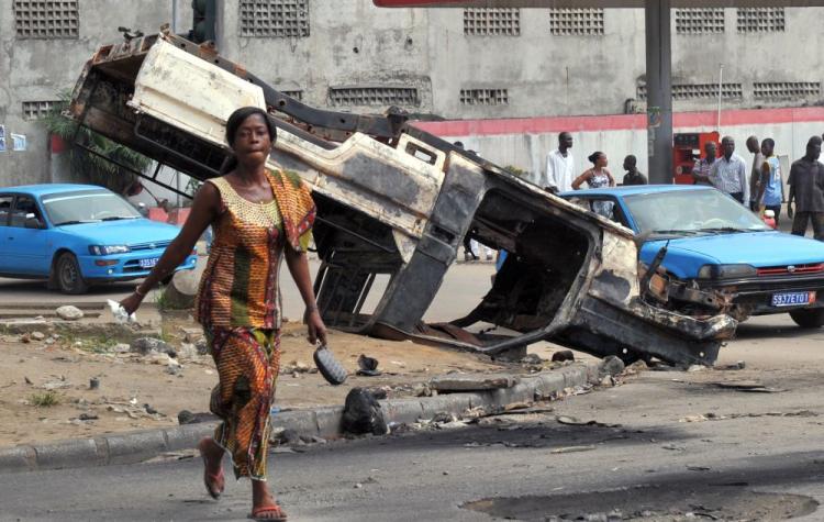 A woman crosses the street in front of a burnt-out United Nations peacekeeper car on Thursday in the Yopougon neighbourhood of Abidjan, home to supporters of Laurent Gbagbo. A mob attacked a UN convoy in Abidjan on December 28, 2010, injuring one peacekeeper with a machete and setting a vehicle alight, the UN said. (Issouf Sanogo/AFP/Getty Images) A woman crosses the street in front of a burnt-out United Nations peacekeeper car on Thursday in the Yopougon neighbourhood of Abidjan, home to supporters of Laurent Gbagbo. A mob attacked a UN convoy in Abidjan on December 28, 2010, injuring one peacekeeper with a machete and setting a vehicle alight, the UN said. (Issouf Sanogo/AFP/Getty Images)