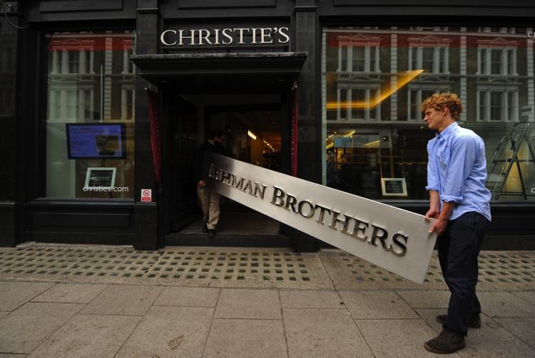 Employees carry a Lehman Brothers sign into Christie's auction house in London this week. The sign was sold as part of the 'Lehman Brothers: Artwork and Ephemera' sale in London on Thursday. (Ben Stansall/AFP/Getty Images)