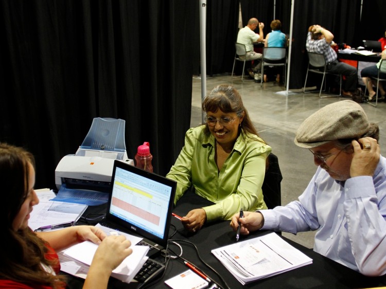 ELUSIVE LOANS: Homeowners Brian Reed (R), and Leticia Reed (L), speak with home-preservation specialist Emily La Rusch to see if they qualify for a home modification loan during a Wells Fargo home-preservation workshop at the Phoenix Convention Center this past March in Phoenix, Arizona. (Joshua Lott/Getty Images)