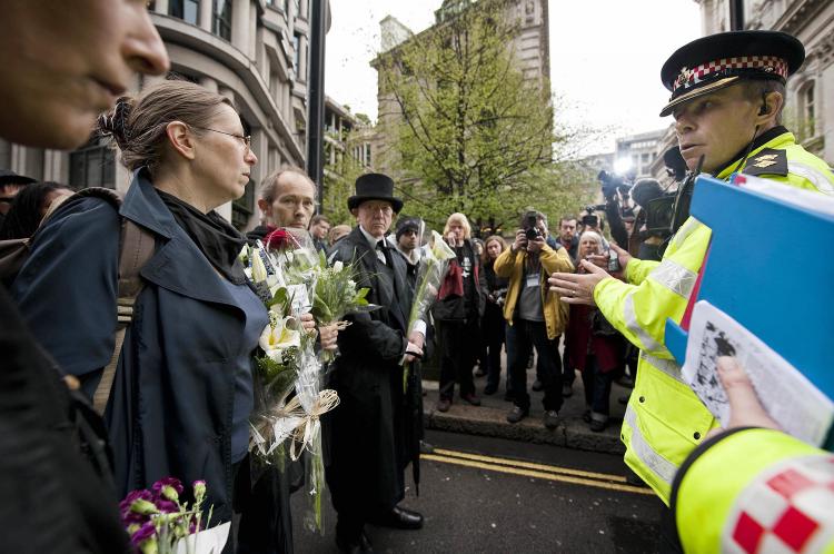Protestors speak to police as they gather to lay flowers at the spot where Ian Tomlinson died during the G20 demonstrations near the Bank of England in London on April 11, 2009. (Ben Stansall/AFP/Getty Images) Protestors speak to police as they gather to lay flowers at the spot where Ian Tomlinson died during the G20 demonstrations near the Bank of England in London on April 11, 2009. (Ben Stansall/AFP/Getty Images)