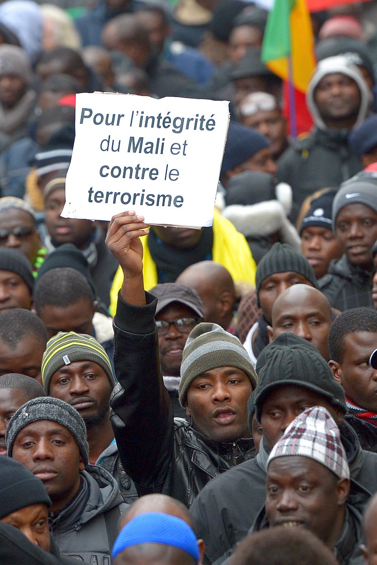 A man waves a placard that reads, "For a united Mali, against terrorism," during a demonstration on Jan. 26 in Montreuil, near Paris in support of the liberation forces sent from France to Mali. As military intervention alleviates some immediate danger in Mali, the nation is left to tackle its long-standing issues in the political arena. (Miguel Medina/AFP/Getty Images)