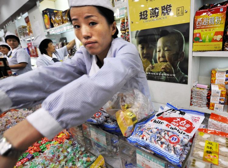A Chinese shopkeeper serves a customer next to packets of White Rabbit candy on sale at a food store in Shanghai. White Rabbit candy has been found to be contaminated with melamine. (Mark Ralston/AFP/Getty Images) A Chinese shopkeeper serves a customer next to packets of White Rabbit candy on sale at a food store in Shanghai. White Rabbit candy has been found to be contaminated with melamine. (Mark Ralston/AFP/Getty Images)