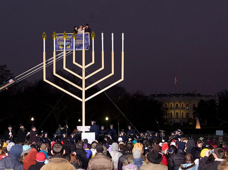 LIGHTING NATIONAL MENORAH: At dusk on Sunday, Dec. 13, the 'National Menorah' was lit. White House Chief of Staff Rahm Emanuel is being lifted in the cherry picker to reach the Hanukkah Menorah, which is said to be the largest in the world. (Lisa Fan/The Epoch Times)