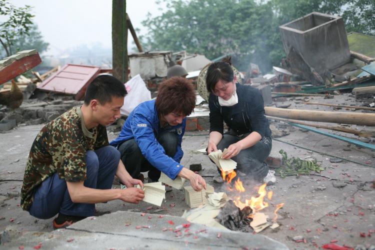 Survivors of the Sichuan earthquake burn paper for their loved ones, a Chinese custom, May 2008. (China Photos/Getty Images) Survivors of the Sichuan earthquake burn paper for their loved ones, a Chinese custom, May 2008. (China Photos/Getty Images)