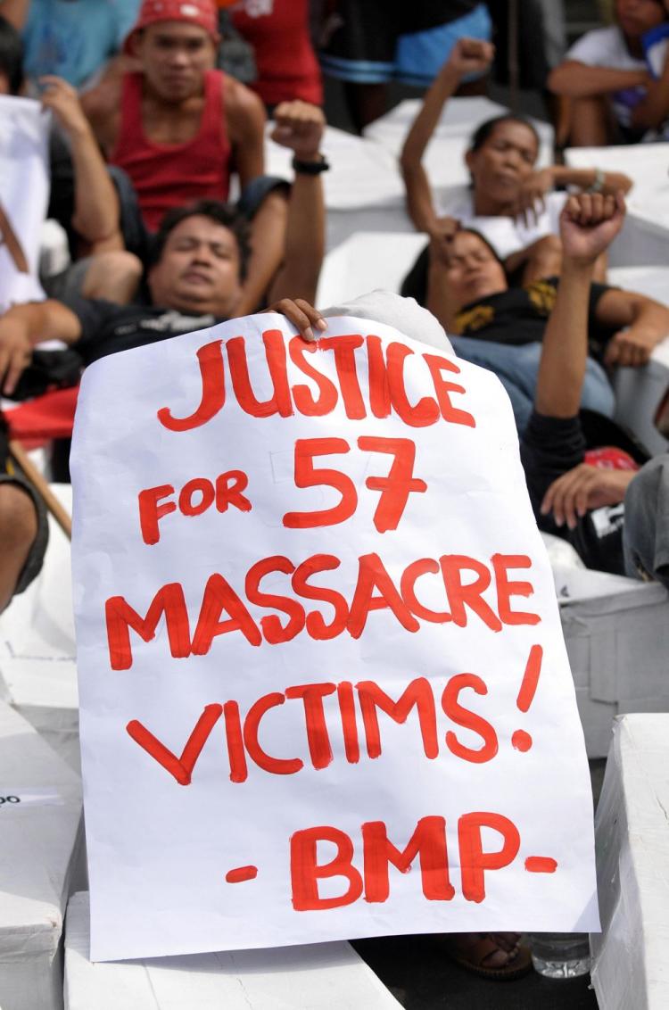 A placard is held up as protesters remembering the 57 victims from Nov. 23 massacre in the southern province of Maguindanao rally in front of the National Bureau of Investigation in Manila on Dec. 10 where a principal accused in the killings is currently  (Jay Directo/AFP/Getty Images)