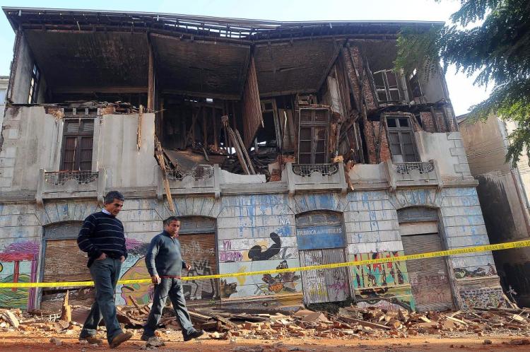 Two men walk past a building in Valparaiso that was heavily damaged by a huge 8.8-magnitude earthquake that rocked Chile on Feb. 27, 2010. (Felipe Gamboa/AFP/Getty Images)