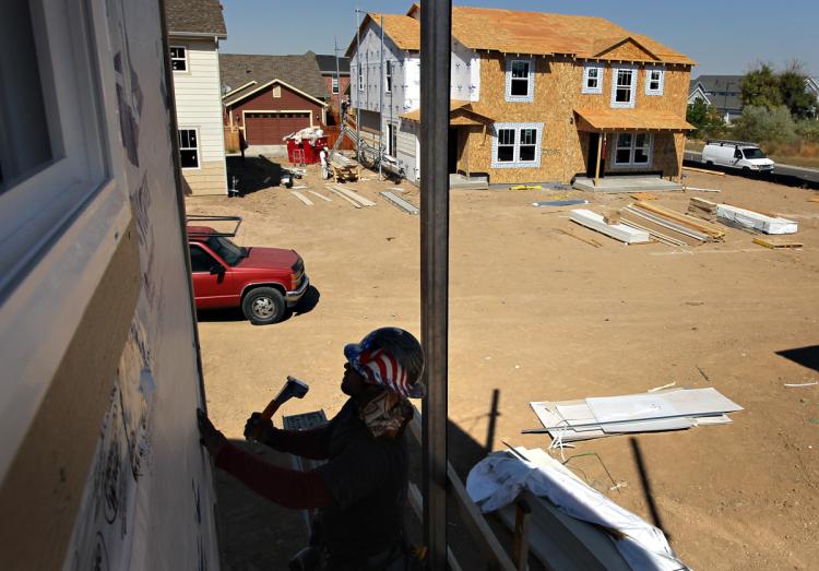 START UPs: A member of a construction crew works on the exterior of a new home on Sept. 21, in the Stapleton neighborhood of Denver, Colorado. Housing starts increased more than expected in August to their highest level in four months, and permits for future home construction rose, the government reported. (John Moore/Getty Images)