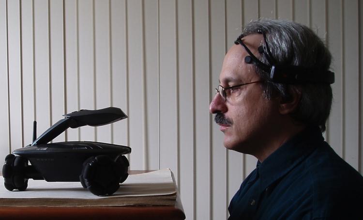 PSYCHIC TOYS: Software developer Robert Oschler looks at his WowWee Rovio robot while wearing an Emotiv EPOC headset. Using the headset, he programmed the robot to be controlled by his thoughts. (Robert Oschler) PSYCHIC TOYS: Software developer Robert Oschler looks at his WowWee Rovio robot while wearing an Emotiv EPOC headset. Using the headset, he programmed the robot to be controlled by his thoughts. (Robert Oschler)