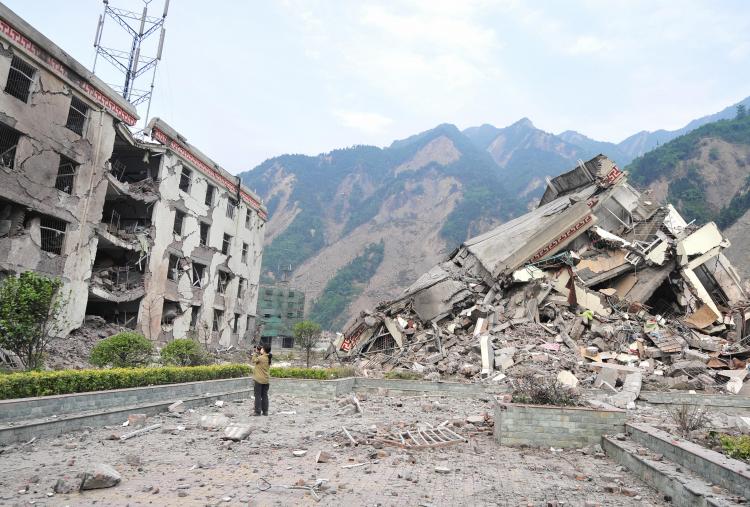 A woman documents the remains of a demolished school in the devastated town of Yingxiu in southwest China's quake-stricken Sichuan province. (Frederic J. Brown/AFP/Getty Images) A woman documents the remains of a demolished school in the devastated town of Yingxiu in southwest China's quake-stricken Sichuan province. (Frederic J. Brown/AFP/Getty Images)