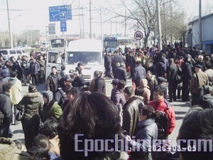 A young girl was brutally beaten at the Beijing Southern Train Station by police who were attempting to stop appellants. Over one thousand angered on-lookers surrounded and beat police, and smashed their car. (The Epoch Times) A young girl was brutally beaten at the Beijing Southern Train Station by police who were attempting to stop appellants. Over one thousand angered on-lookers surrounded and beat police, and smashed their car. (The Epoch Times)
