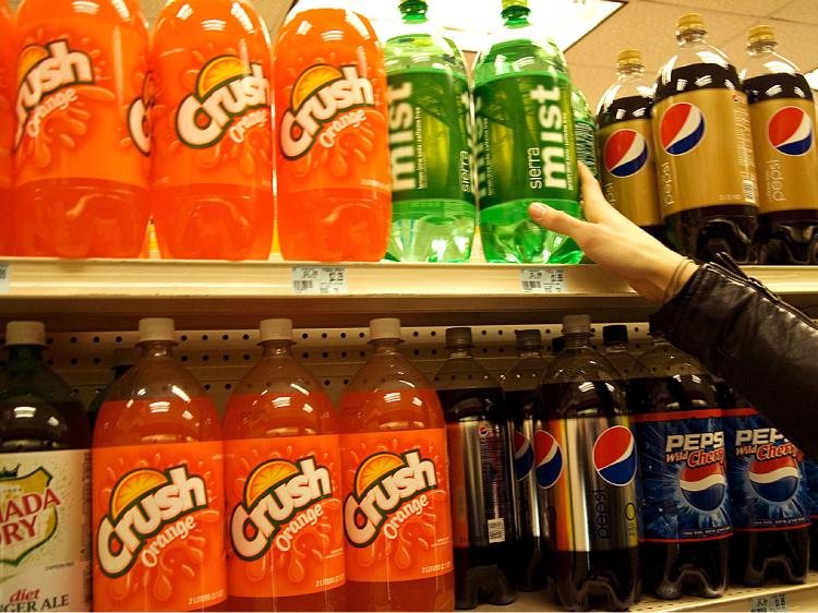 A New Yorker reaches for a bottle of soda at a store in Midtown Manhattan on Tuesday. Governor David Paterson's proposed budget would add a 12 cent tax on cans of soda. (Jack Phillips/The Epoch Times)