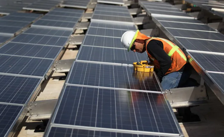 A worker finishes installing solar panels funded by federal stimulus funds atop a government building in Lakewood, Colorado in this file photo. (John Moore/Getty Images)