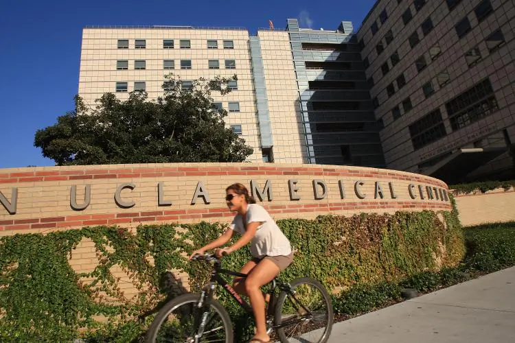 A student rides a bike past Ronald Reagan UCLA Medical Center in Los Angeles, Calif. (David McNew/Getty Images)