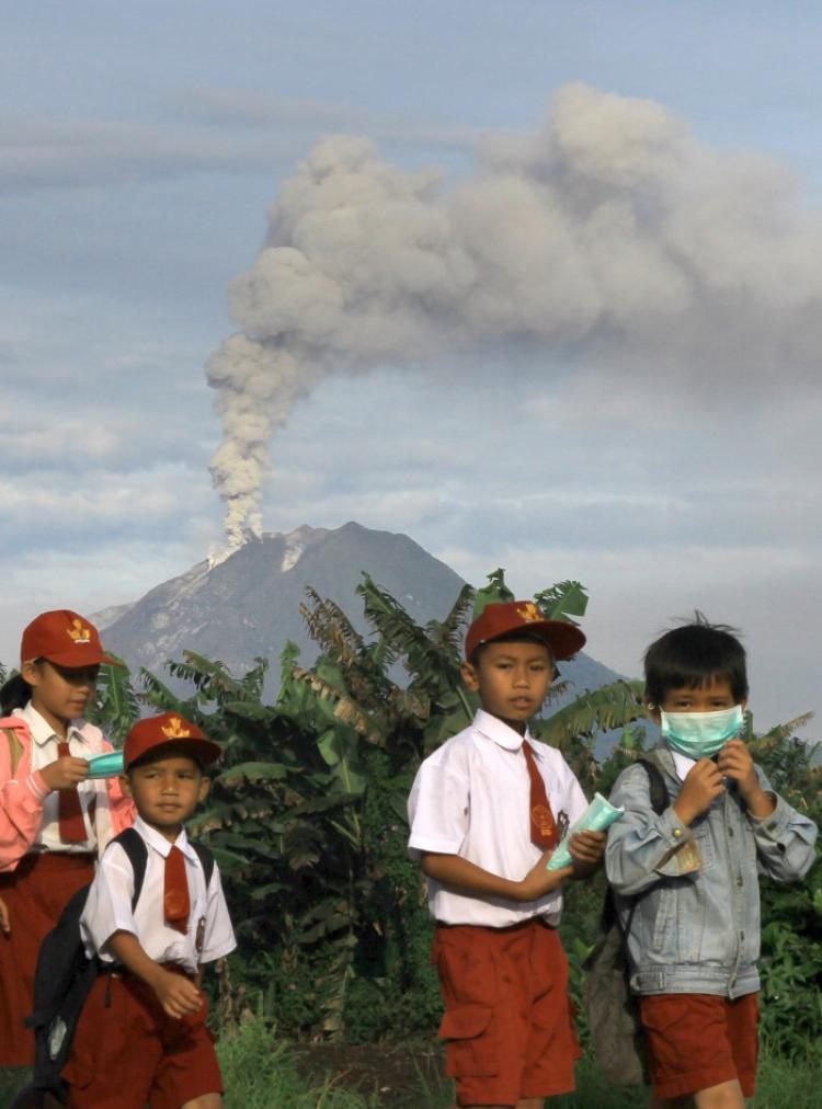 Indonesian school children walk home after schools were suspended in Tanah Karoh due to the eruption of Mount Sinabung (background) in North Sumatra on August 30, 2010. (Suntanta Aditya/AFP/Getty Images)