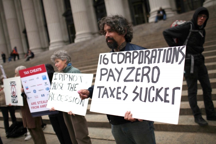 TAXES DEBATED: Protesters against American corporate tax loopholes demonstrate outside of the James A. Farley Main Post Office this past April in NYC. Citizens for Tax Justice analyzed 12 of America's Fortune 500 companies and found that 10 paid no taxe (Spencer Platt/Getty Images) TAXES DEBATED: Protesters against American corporate tax loopholes demonstrate outside of the James A. Farley Main Post Office this past April in NYC. Citizens for Tax Justice analyzed 12 of America's Fortune 500 companies and found that 10 paid no taxe (Spencer Platt/Getty Images)