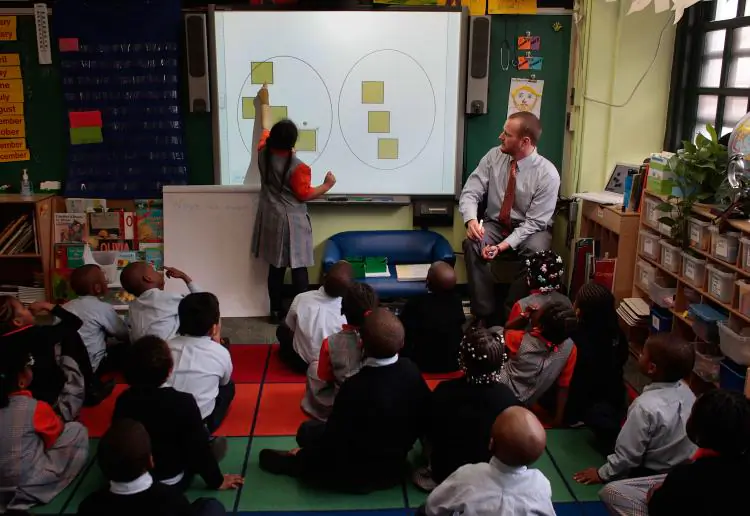 Teacher Shawn Abernathy (R) teaches math concepts using a modern computer projection board at Harlem Success Academy, a free, public elementary charter school in the Harlem neighborhood of New York City. (Chris Hondros/Getty Images)