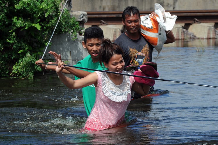 Thai residents hold onto a rope while they walk through floodwaters in Pathum Thani province, suburban Bangkok, on October 16, 2011. (Pornchai Kittiwongsakul/AFP/Getty Images) Thai residents hold onto a rope while they walk through floodwaters in Pathum Thani province, suburban Bangkok, on October 16, 2011. (Pornchai Kittiwongsakul/AFP/Getty Images)