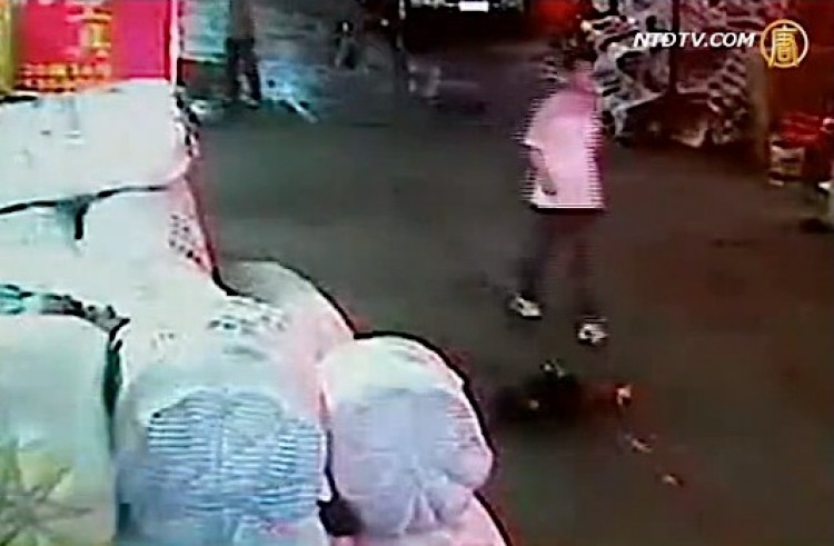 A man walks around Yueyue seconds after she had been run over by a mini-van. (Screenshot NTDTV) A man walks around Yueyue seconds after she had been run over by a mini-van. (Screenshot NTDTV)