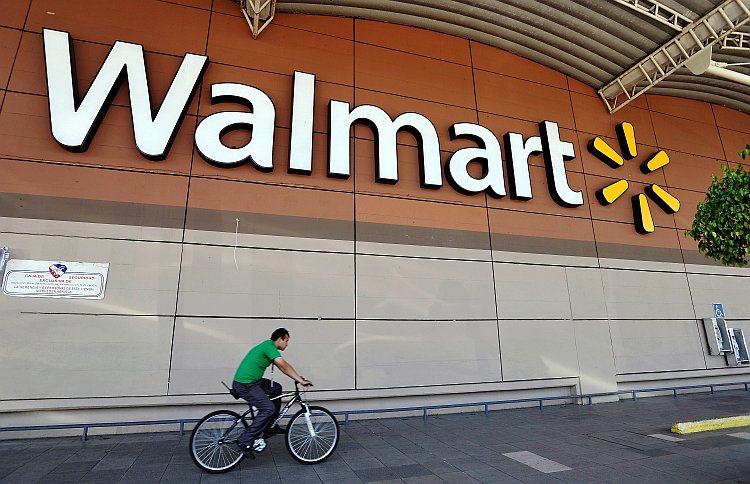 A man rides his bike past a Walmart store in Mexico City, Mexico A man rides his bike past a Walmart store in Mexico City, Mexico