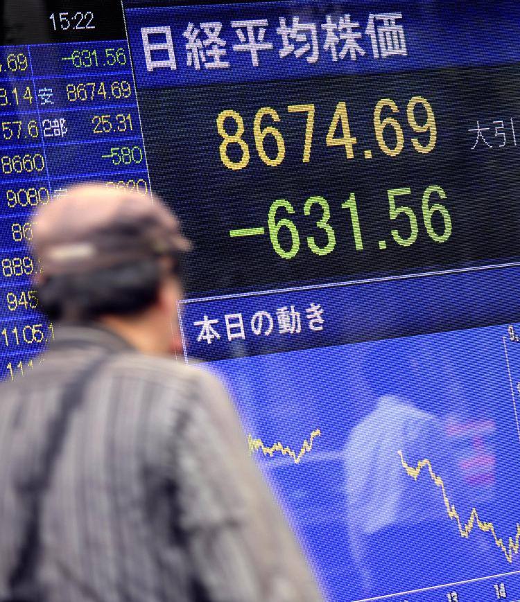 A man looks at an electronic quotation board flashing the Nikkei key index of the Tokyo Stock Exchange (TSE) in front of a securities company in Tokyo.  (Toru Yamanaka/AFP/Getty Images)