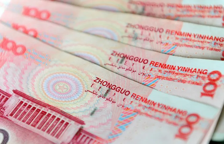 An illustration of Chinese currency 100 yuan notes issued by the People's Bank of China, with an image of parliament building the Great Hall of the People on the rear in Beijing. (Frederic J. Brown/AFP/Getty Images)