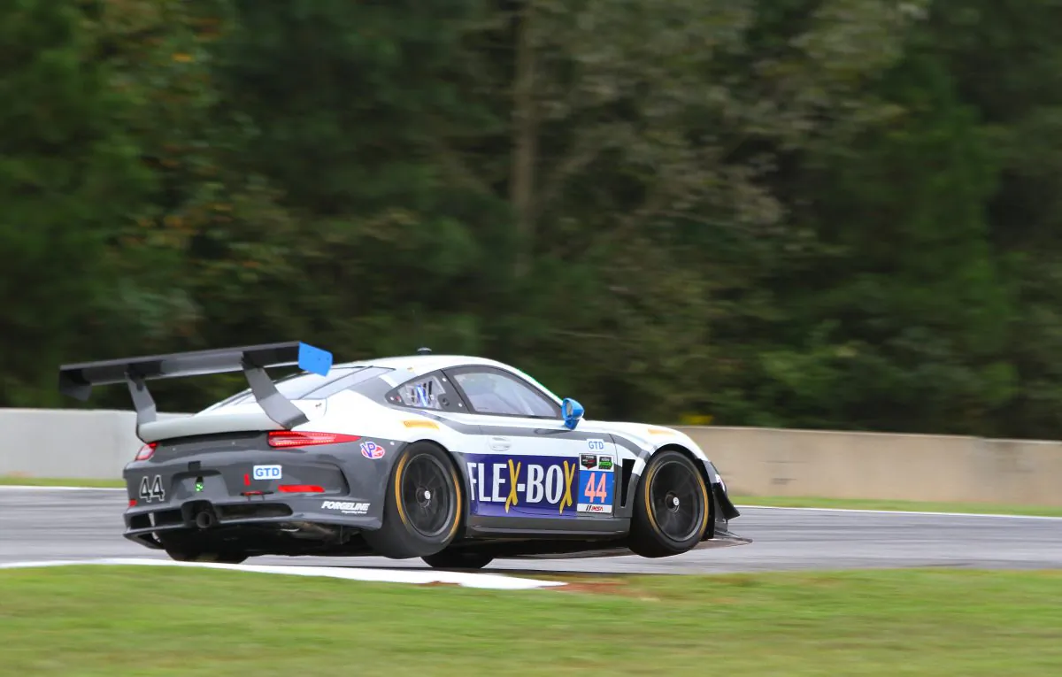 The #44 Magnus Racing Porsche bounces off a curb at Turn Three during morning practice. (Chris Jasurek/Epoch Times)