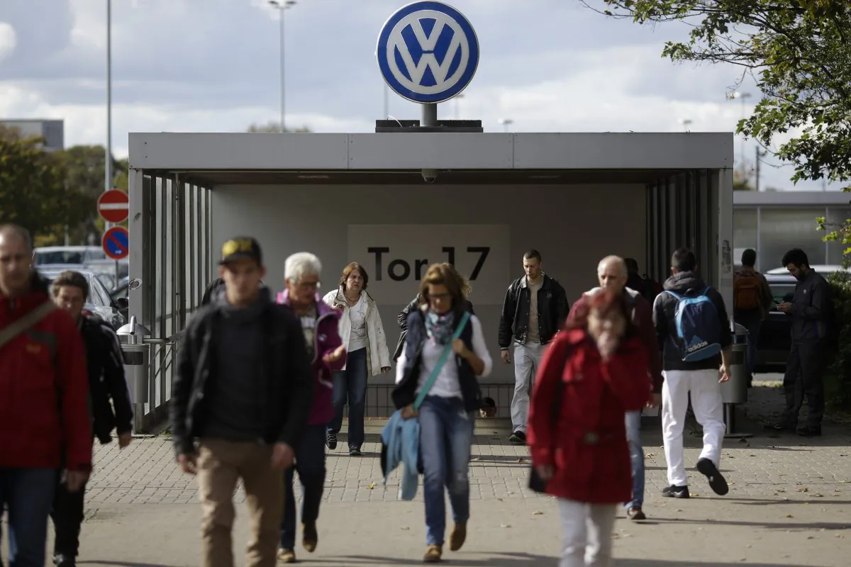 In this photo taken on Sept. 29, 2015 people leave Volkswagen factory at Gate 17 in the city Wolfsburg, Germany. (AP Photo/Markus Schreiber)