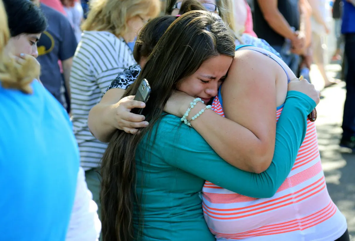 Jessica Vazquez, left, hugs her aunt Leticia Acaraz as they await word on Acaraz's daughter at the local fairgrounds after a shooting at Umpqua Community College in Roseburg, Ore., on Thursday, Oct. 1, 2015. (AP Photo/Ryan Kang)