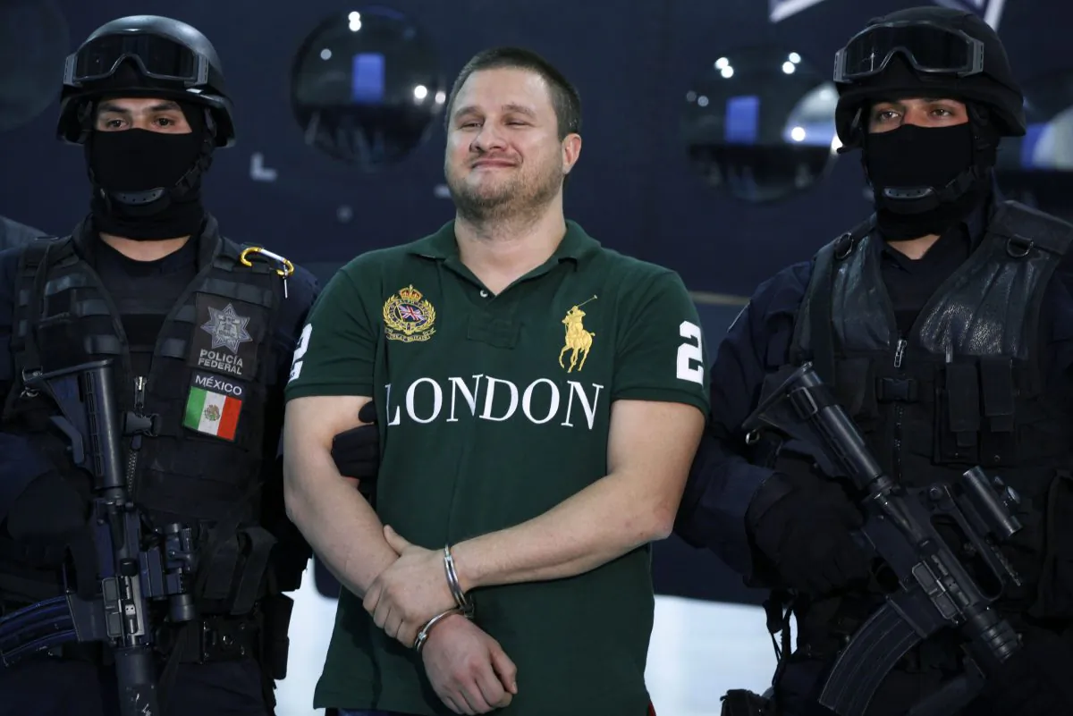 In this Tuesday Aug. 31, 2010, file photo, Federal Police escort Texas-born fugitive Edgar Valdez Villarreal, alias "the Barbie," center, during his presentation to the press in Mexico City. (AP Photo/Alexandre Meneghini)