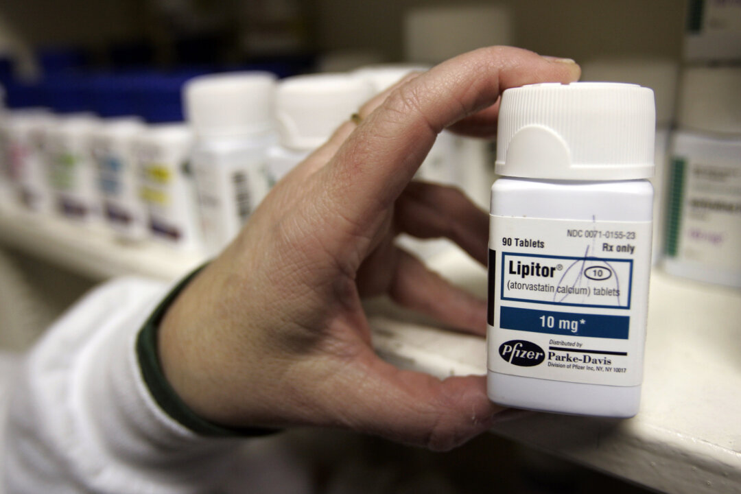 A pharmacist holds a bottle of the prescription drug Lipitor at a Maximart pharmacy in Palo Alto, Calif., on Dec. 14, 2007. (Paul Sakuma/AP)