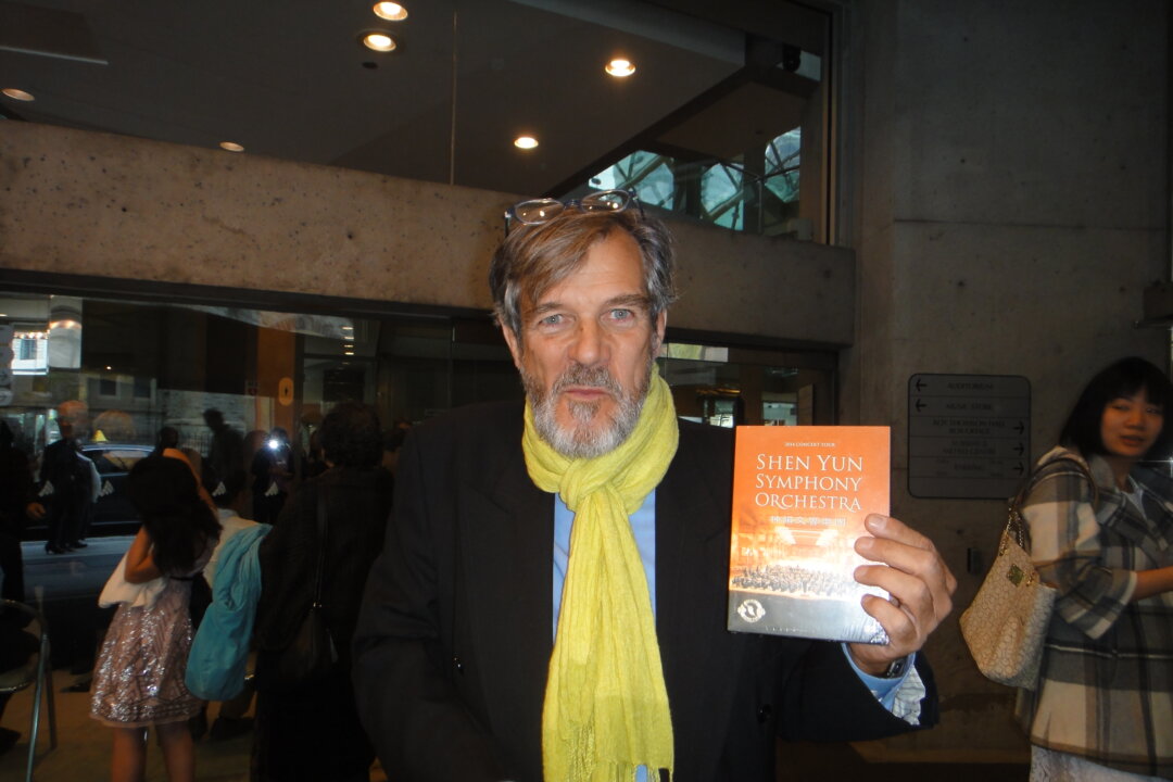 Raymond Rouillard poses for a photo with a Shen Yun Symphony Orchestra DVD at the Roy Thomson Hall on Oct. 3, 2015 in Toronto. (Dongyu Teng/Epoch Times)